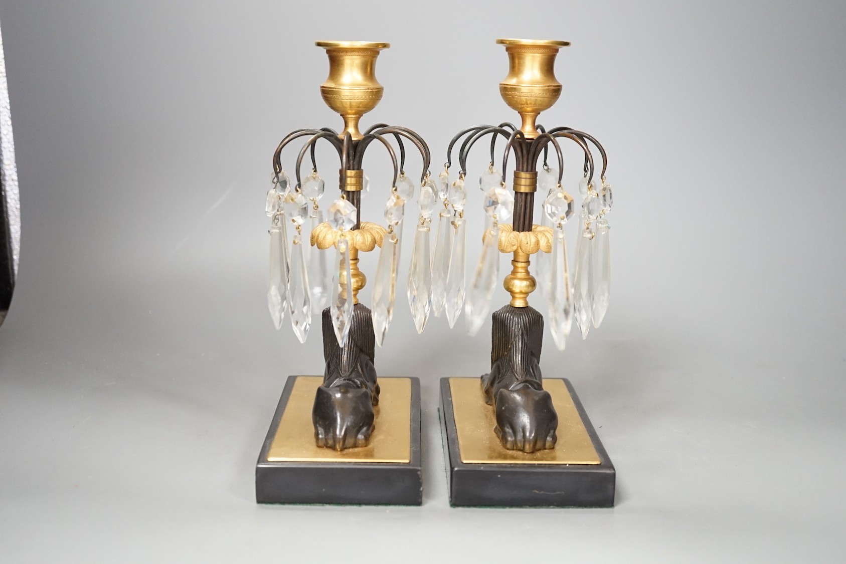 A pair of lustre drop 'sphinx' candlesticks - 23cm tall
